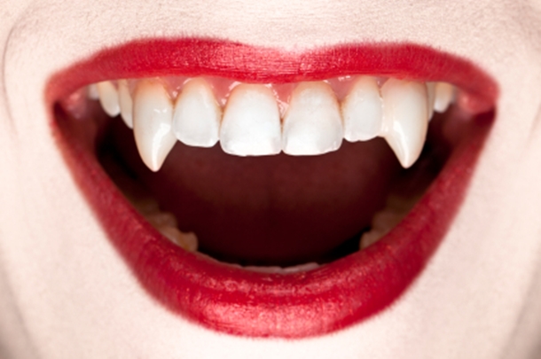 Red lips exposing vampire teeth.