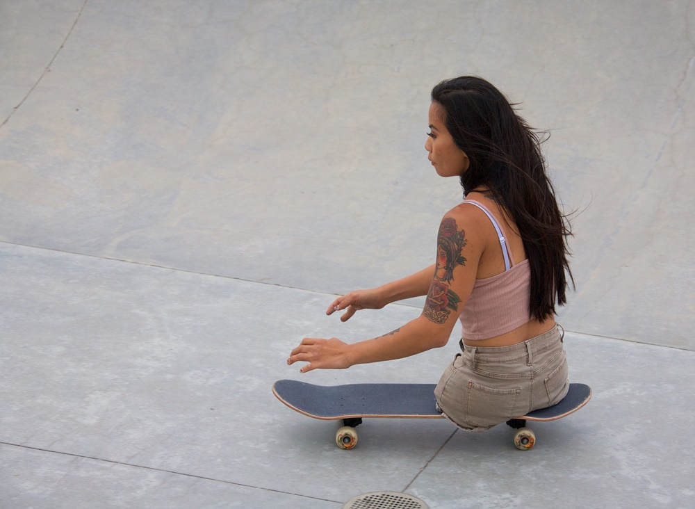 Woman amputee on skateboard.