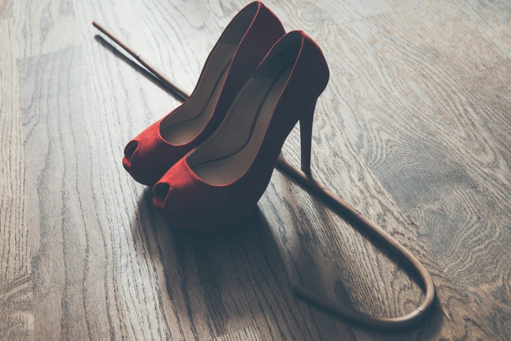 Kinky red shoes with BDSM cane.