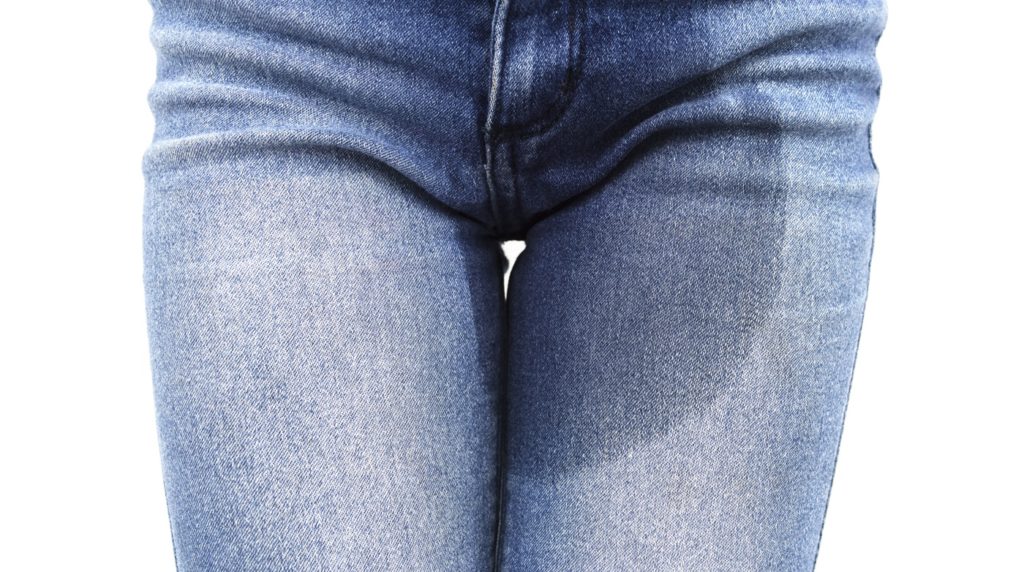 Woman in jeans wetting herself for omorashi, a Japanese fetish.