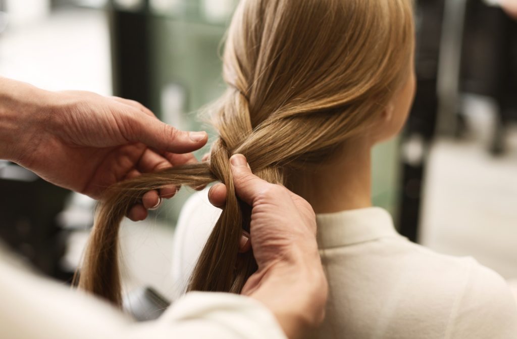 Man Braiding Woman's Hair