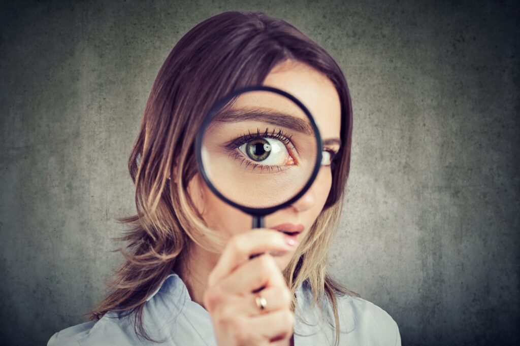 Woman Looking through Magnifying Glass